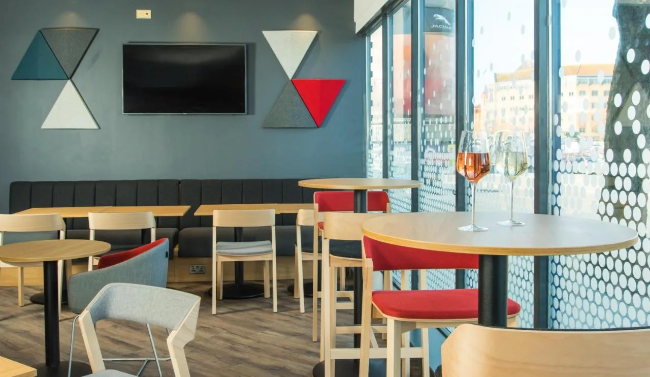 a restaurant with tables and chairs and a tv at Holiday Inn Express Bristol City Centre by IHG in Bristol