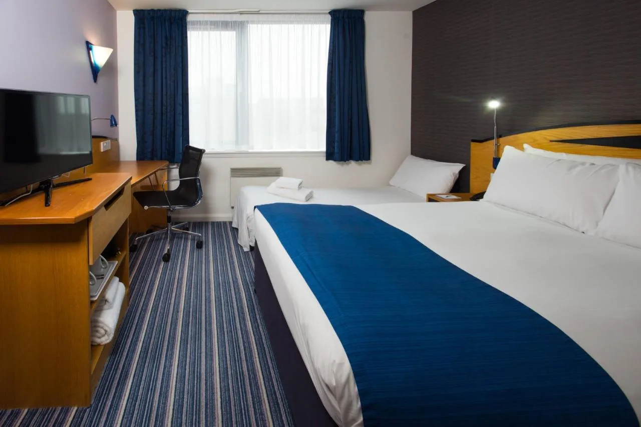 a hotel room with a bed and a desk and a television at Holiday Inn Express Bristol City Centre by IHG in Bristol