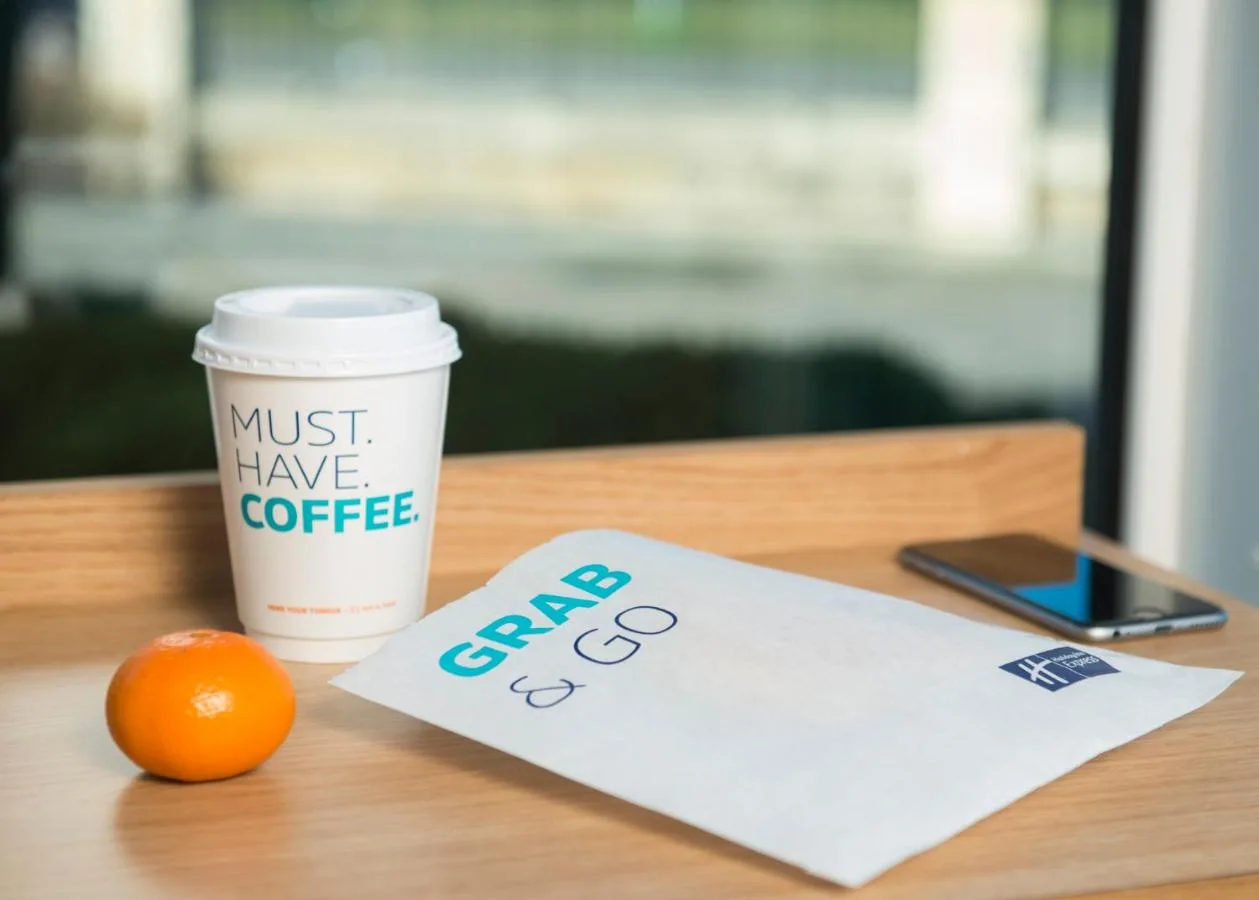 a cup of coffee and an orange on a table at Holiday Inn Express Bristol City Centre by IHG in Bristol